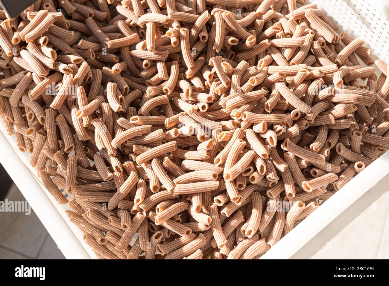 cesto di pasta fresca, maccheroni di pasta integrale, prodotto a metà mano Foto Stock