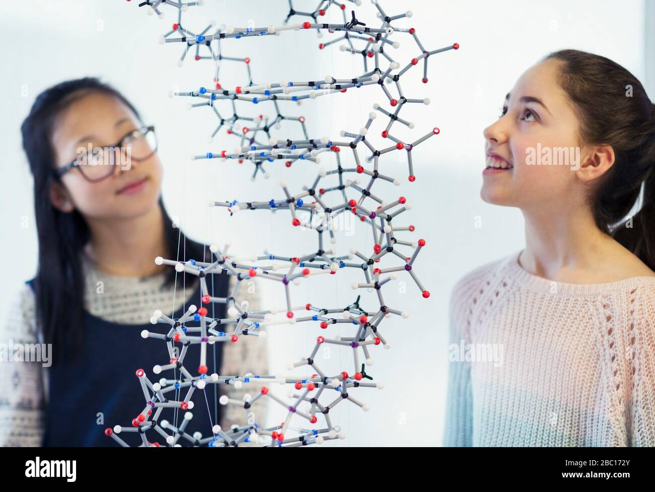 Curiosa studentessa studentessa che esamina la struttura molecolare in classe Foto Stock