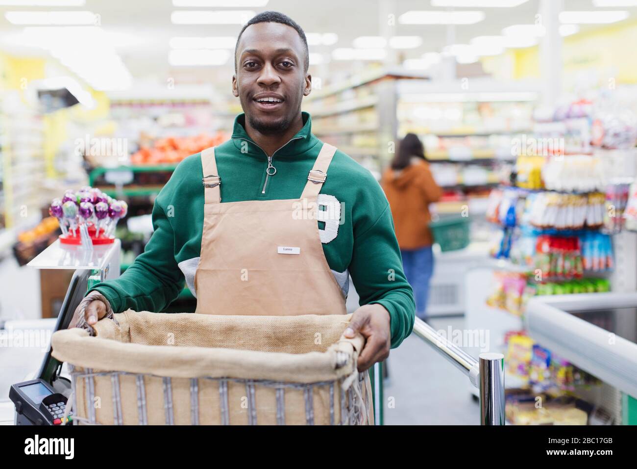 Ritratto sicuro drogheria maschile che lavora in supermercato Foto Stock