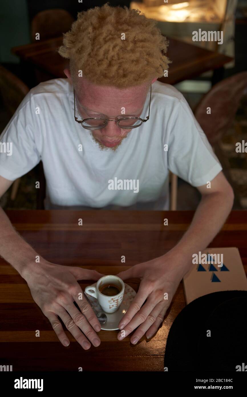 Vista dall'alto di un albino che prende una tazza di caffè Foto Stock