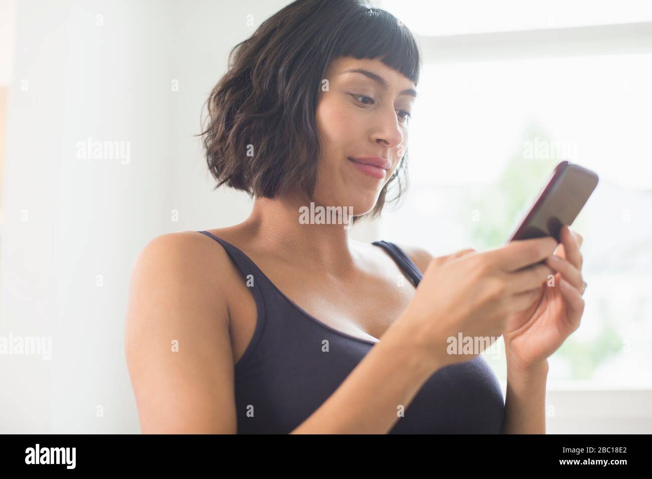 Donna in reggiseno con smartphone Foto Stock