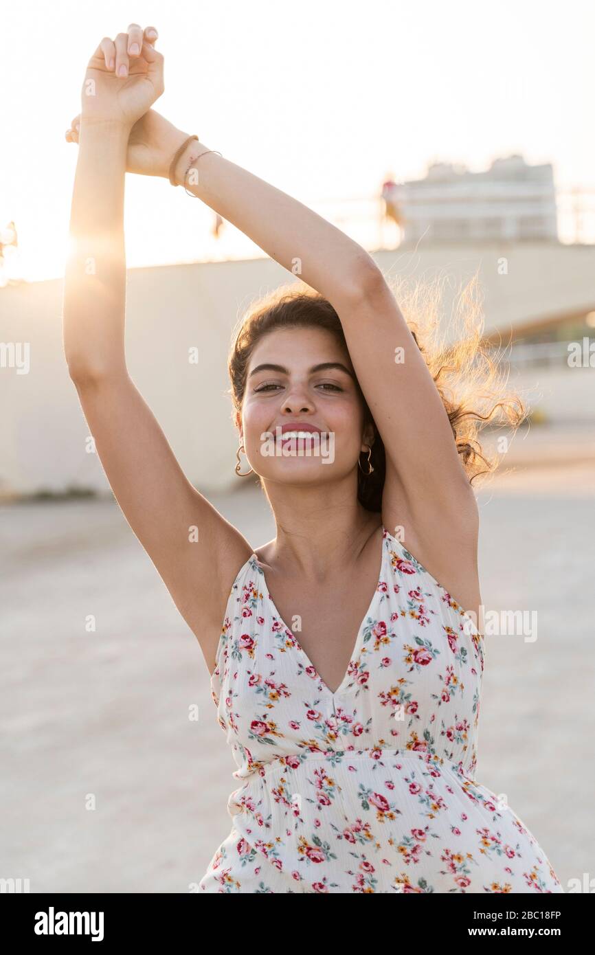 Ritratto di giovane donna felice all'aperto al tramonto Foto Stock