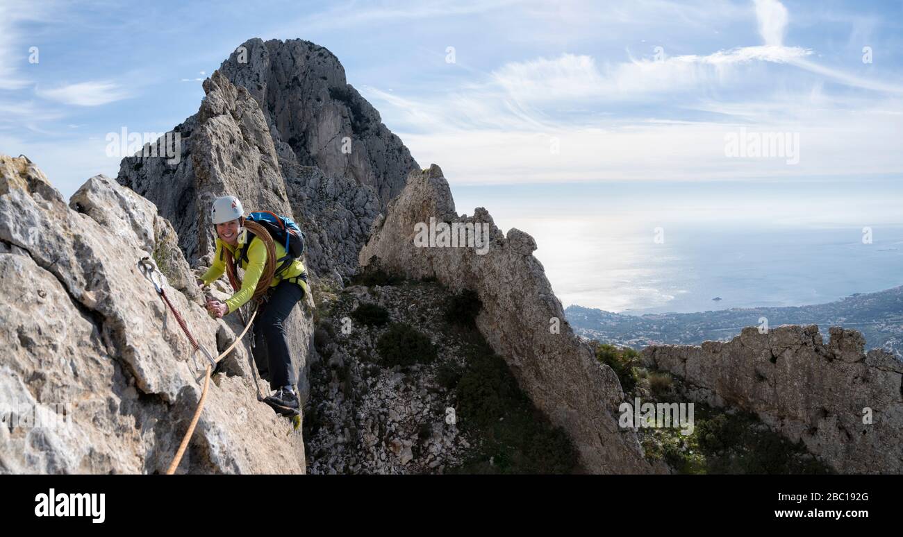 Donna sorridente alpinismo a Bernia Ridge, Costa Blanca, Alicante, Spagna Foto Stock