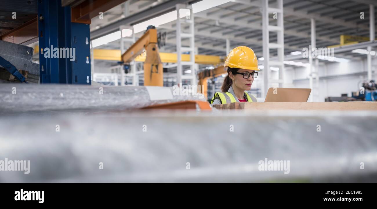 Supervisore femminile che utilizza il computer portatile in fabbrica Foto Stock