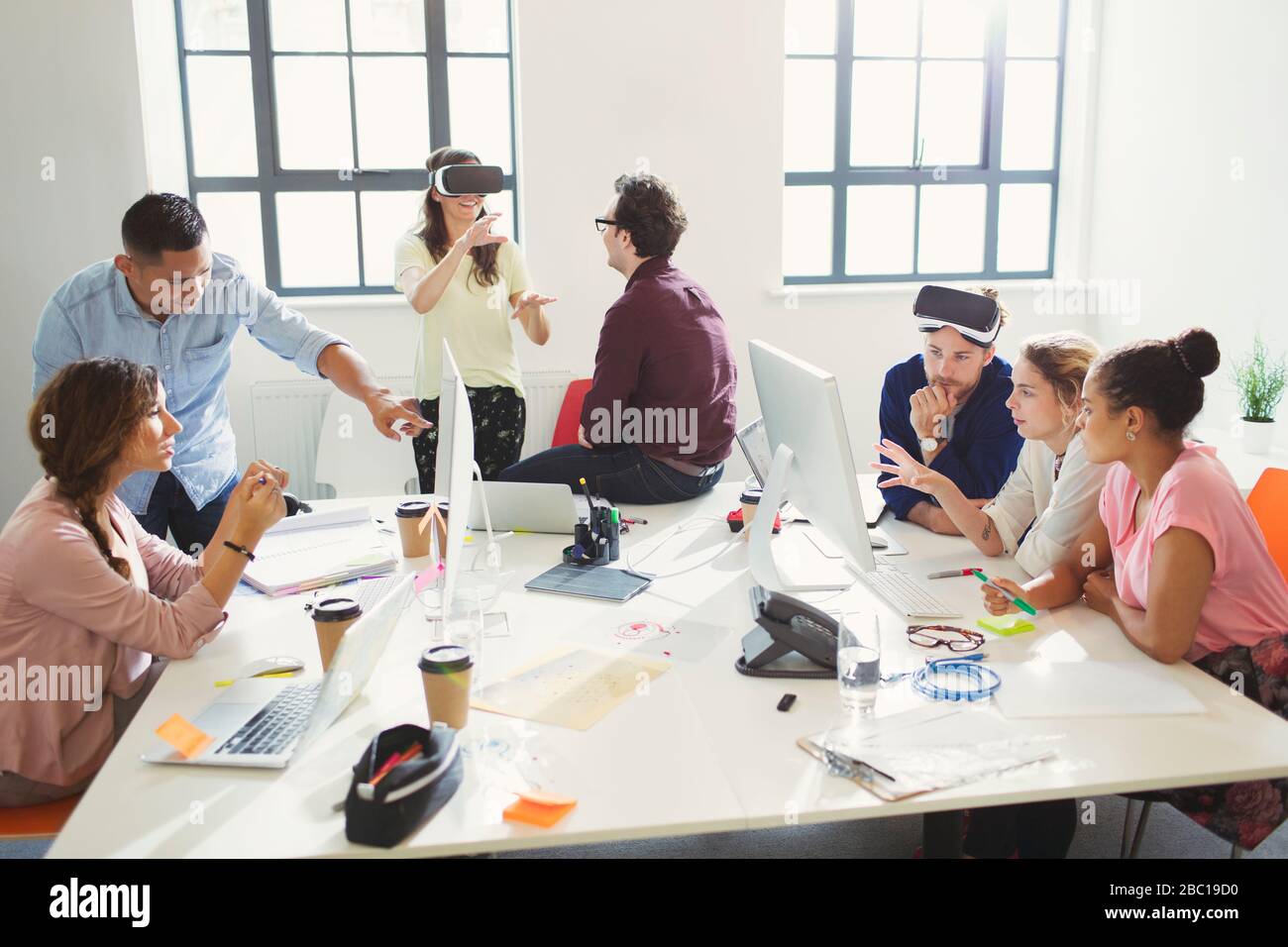 Programmatori di computer che programmano occhiali simulatore di realtà virtuale in ufficio open space Foto Stock