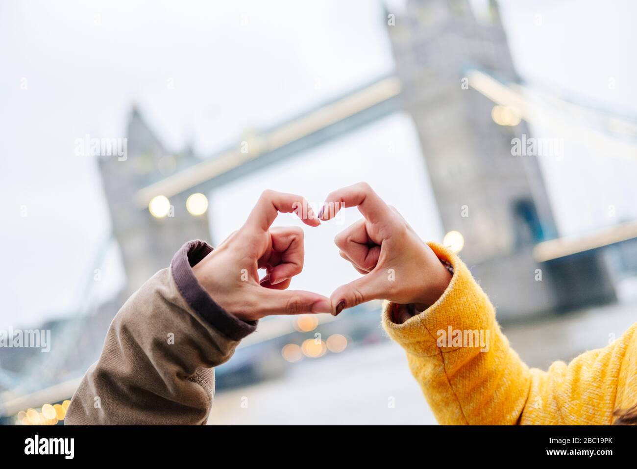 Londra, Regno Unito, coppia che fa la cornice del dito a forma di cuore Foto Stock