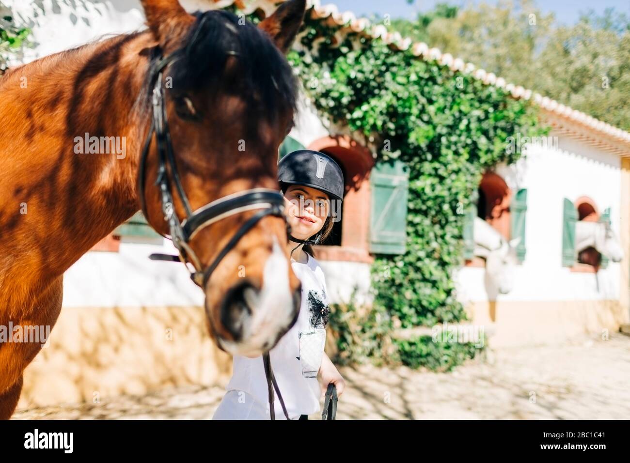 Adolescente con sindrome di Down prendersi cura del cavallo e preparare cavallo a cavalcare Foto Stock