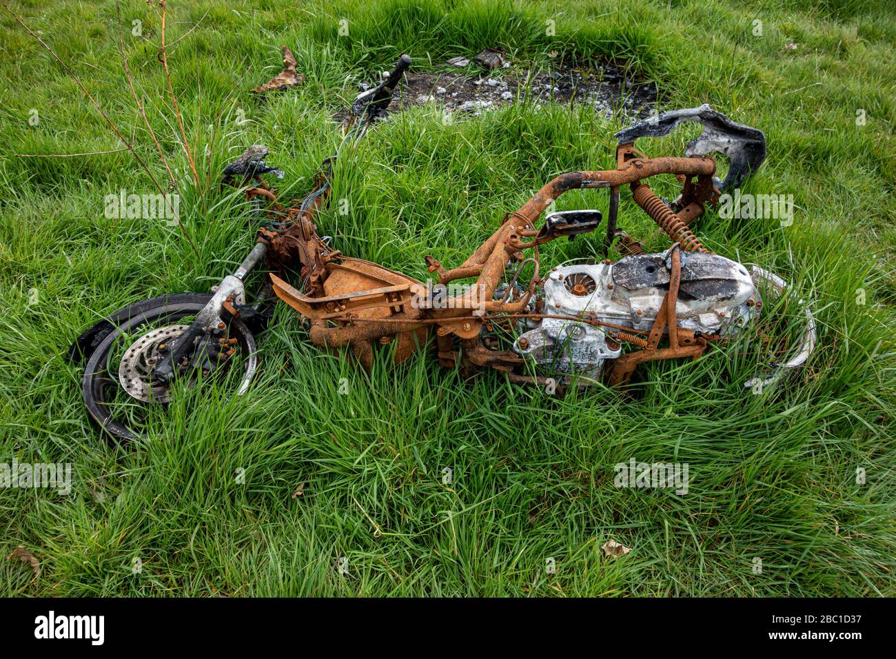 Moto bruciata in un parco vicino Foto Stock