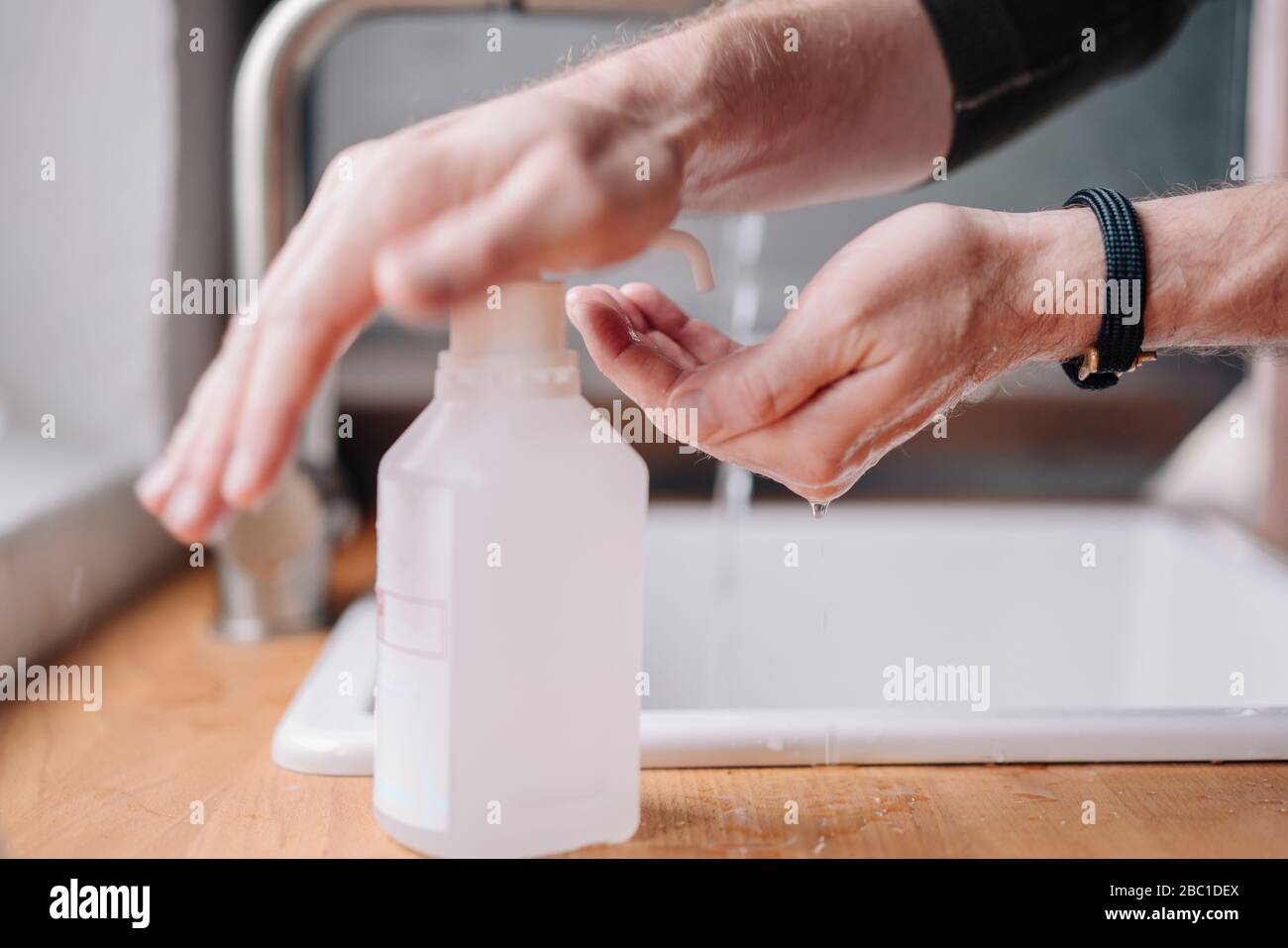 Primo piano dell'uomo disinfettante le mani Foto Stock
