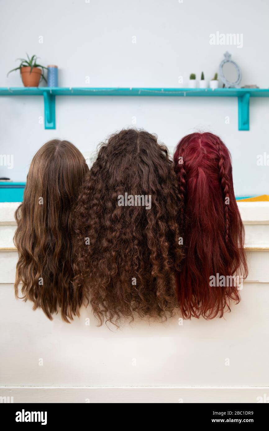 Vista posteriore di tre sorelle con capelli lunghi Foto Stock