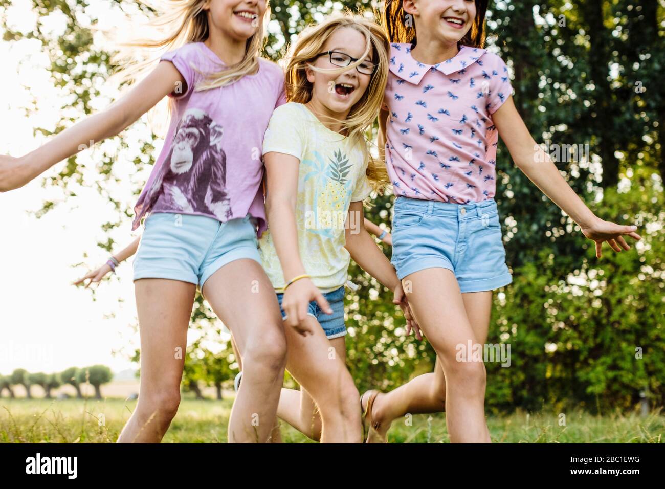 Ragazze felici che corrono su un campo in campagna Foto Stock