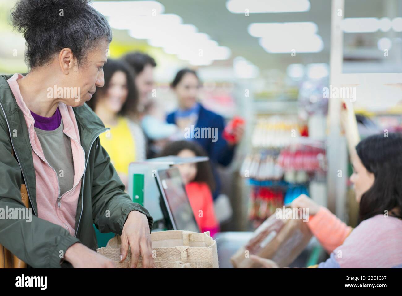 Cassiere che aiuta il cliente alla cassa del supermercato Foto Stock