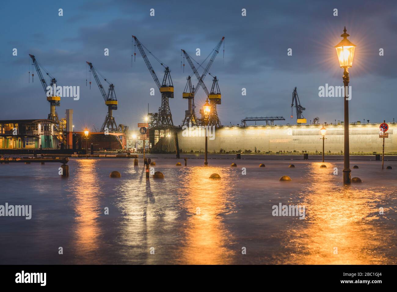 Germania, Amburgo, mercato del pesce di Altona durante l'alluvione con gru portuali in background Foto Stock