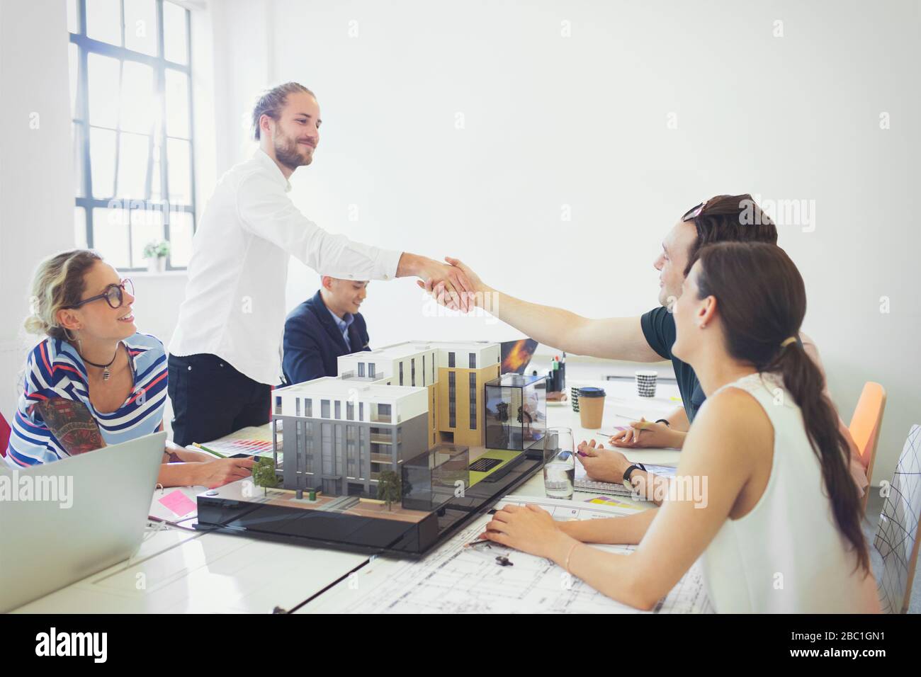 Gli architetti si stringono a mano nella sala conferenze Foto Stock