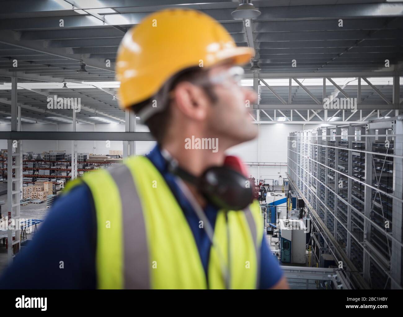 Lavoratore maschile che guarda via sulla piattaforma in fabbrica Foto Stock