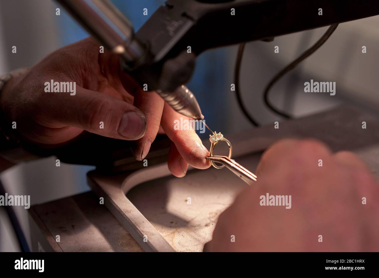 Uomo che lavora in un anello di saldatura con una saldatrice Foto Stock