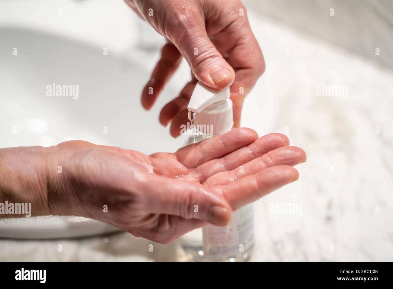 Uomo che lava le mani, usando l'igienizzatore, primo piano Foto Stock