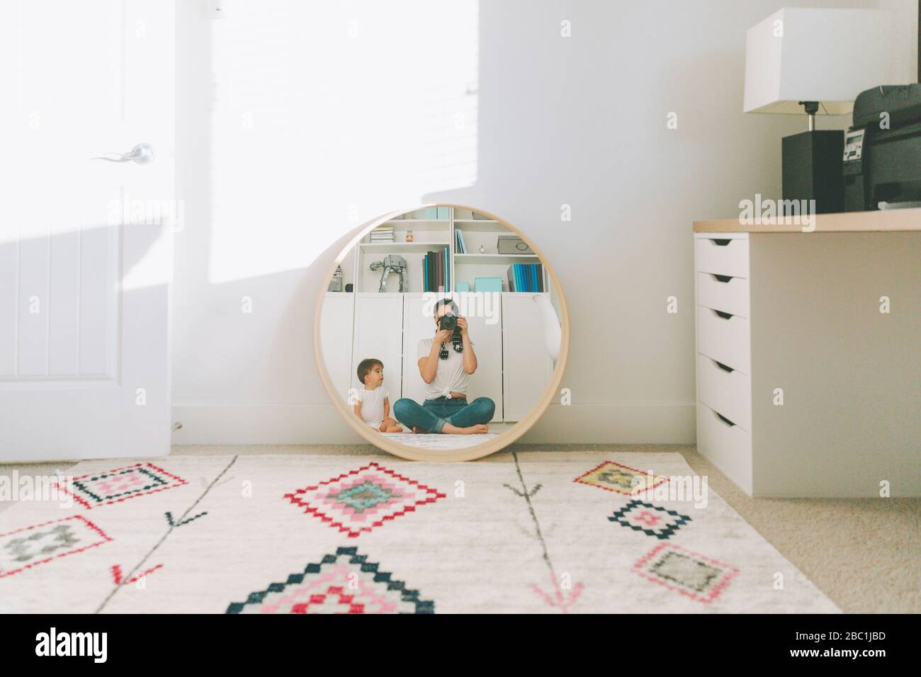 Riflessione della madre che prende una fotografia di se stessa e del bambino nello specchio Foto Stock