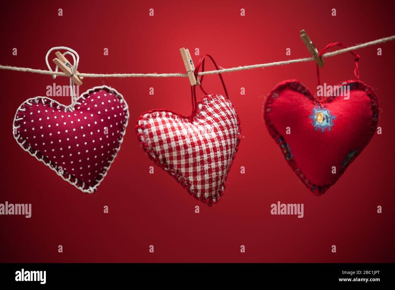 Cuori colorati di tessuto su sfondi rossi. Concetto di amore di San  Valentino Foto stock - Alamy