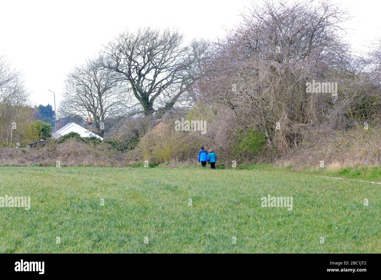 Loose Village, Kent, Regno Unito. Coppia che cammina da sola attraverso un campo Foto Stock