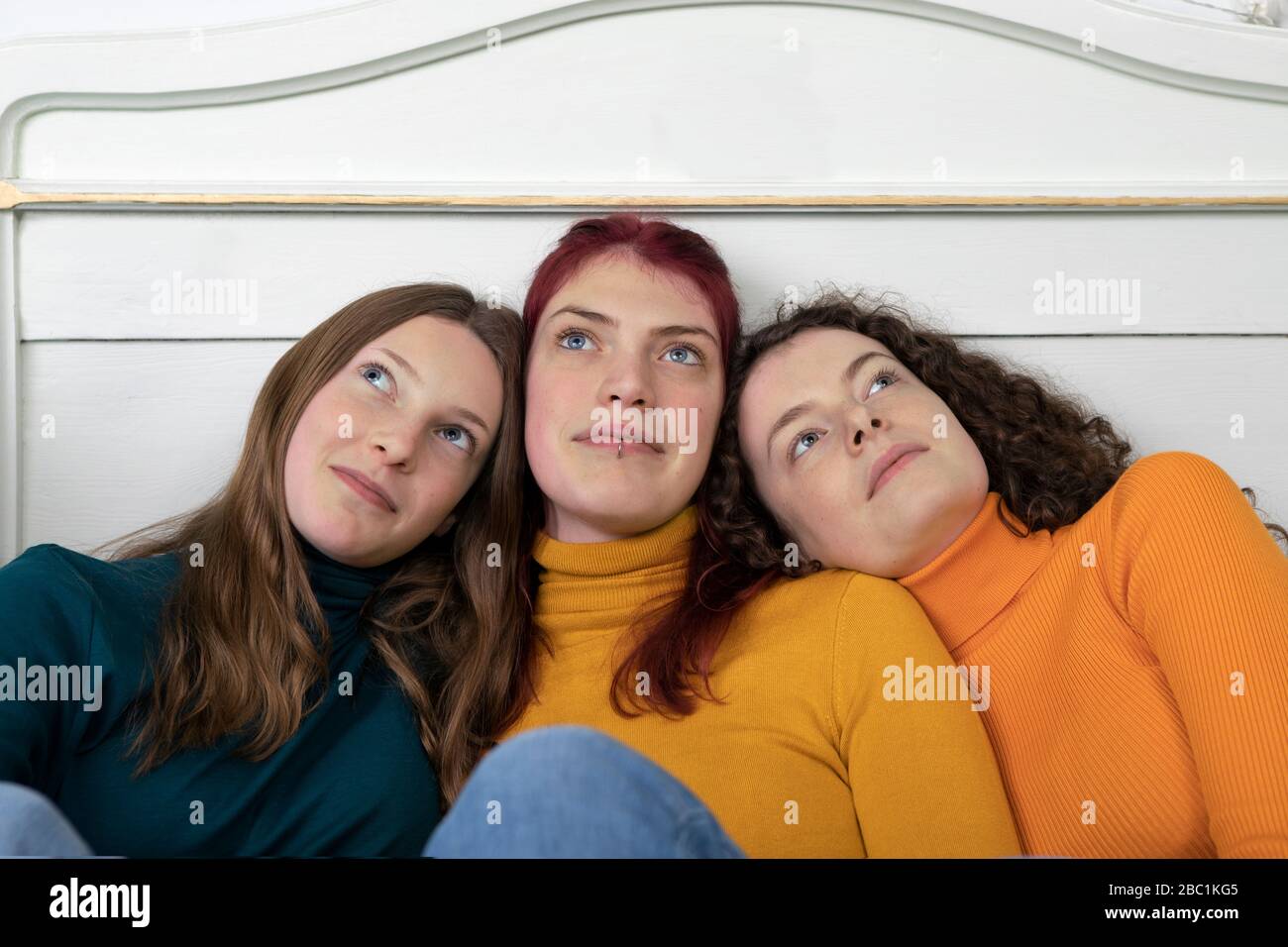 Ritratto di tre sorelle testa a testa guardando a distanza Foto Stock