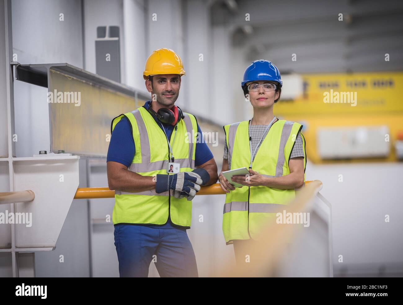 Supervisori sicuri del ritratto con tablet digitale sulla piattaforma in fabbrica Foto Stock