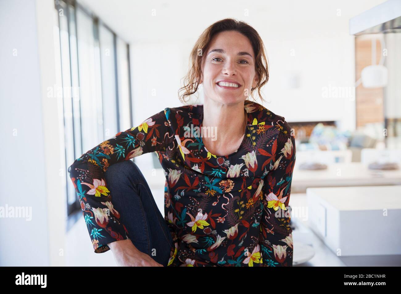 Ritratto sorridente, fiduciosa donna brunetta in cucina Foto Stock