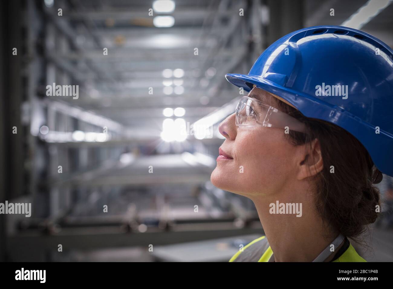Profilo femmina operatrice pensiva cercando in fabbrica Foto Stock
