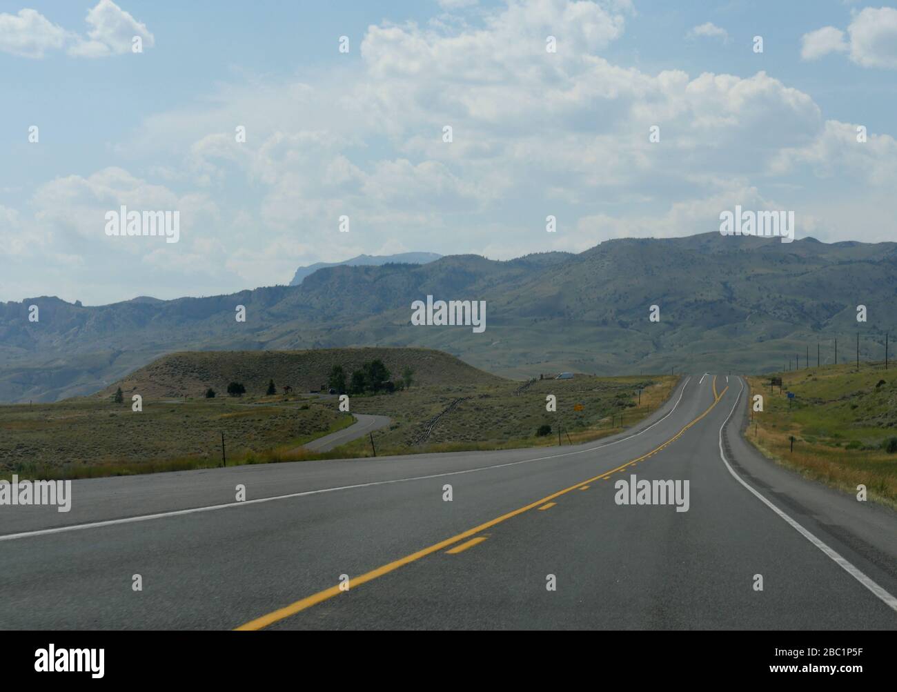 Strade asfaltate e paesaggi in un giro in auto nel Wyoming, ampio colpo. Foto Stock