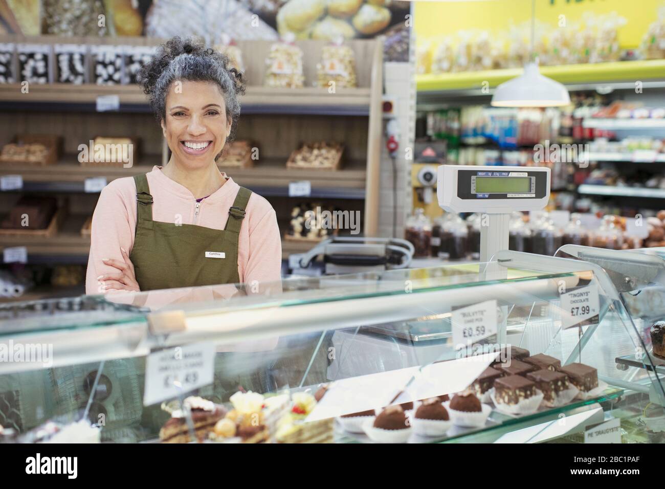 Ritratto lavoratore fiducioso dietro forno vetrina in supermercato Foto Stock