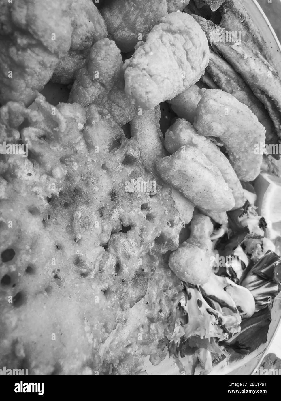 mischia i pesci fritti e il piatto di pesce con lattuga fresca e succo di limone Foto Stock