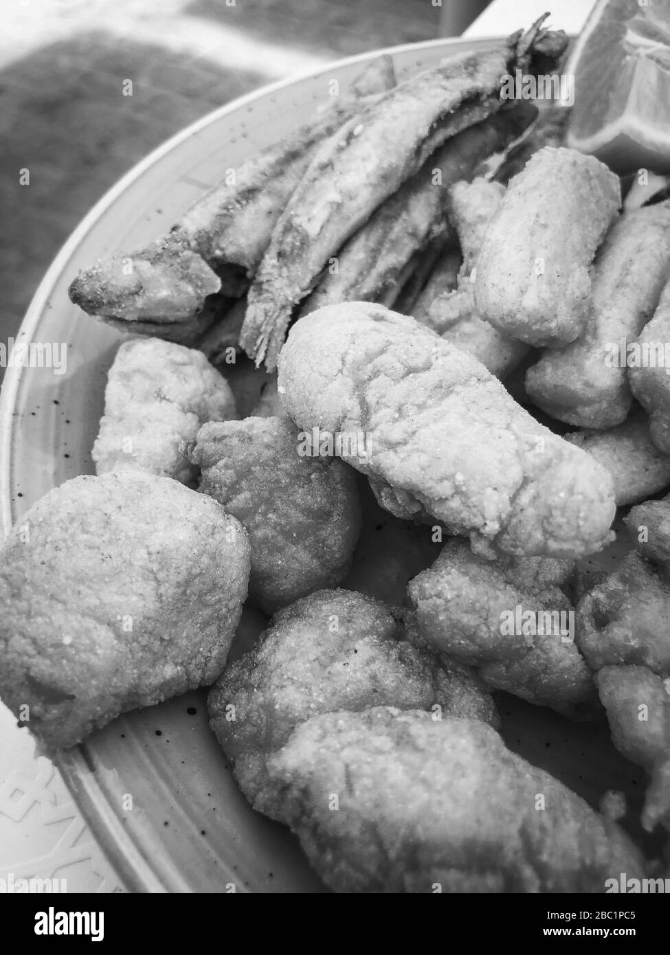 mischia i pesci fritti e il piatto di pesce con lattuga fresca e succo di limone Foto Stock