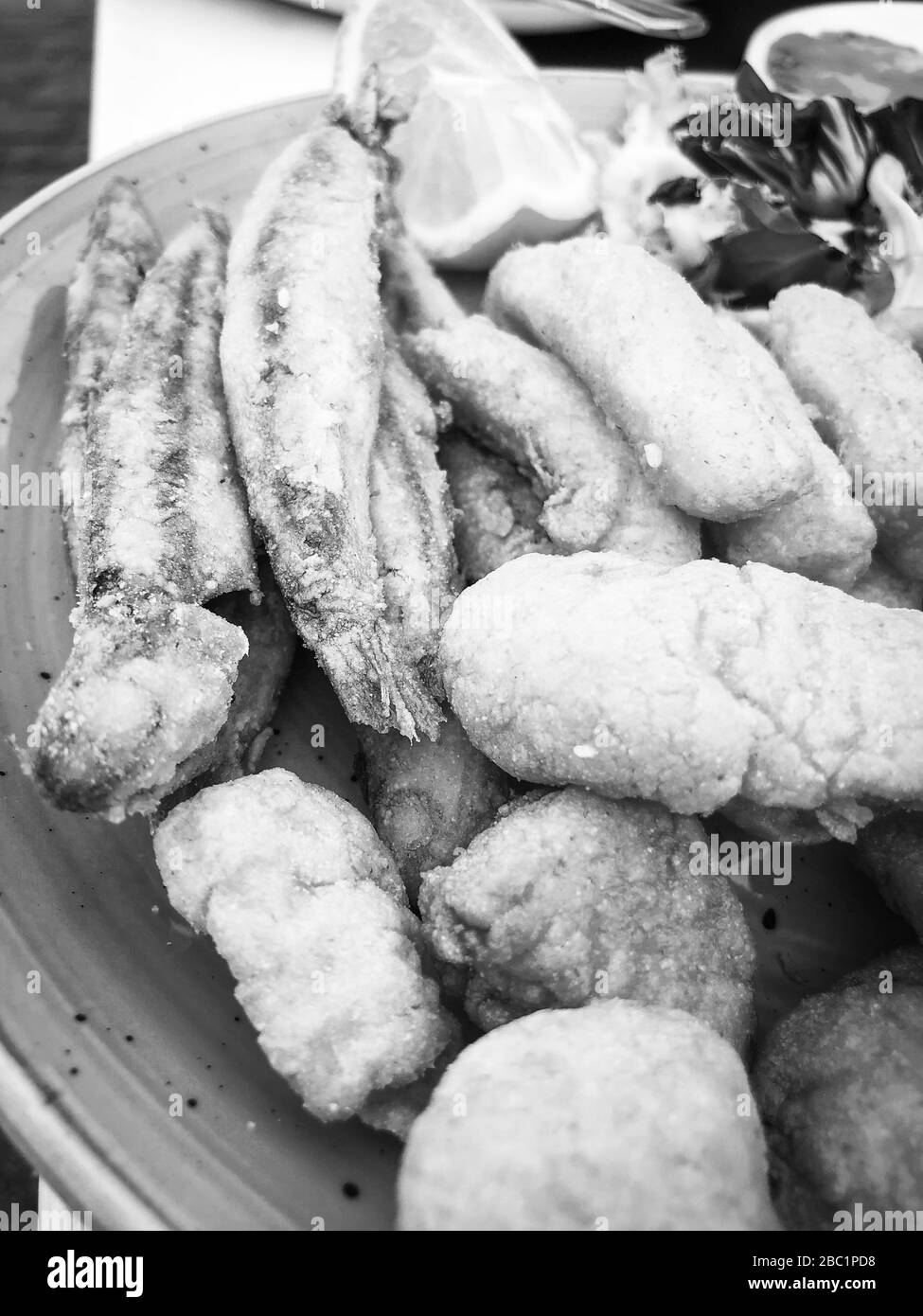 mischia i pesci fritti e il piatto di pesce con lattuga fresca e succo di limone Foto Stock
