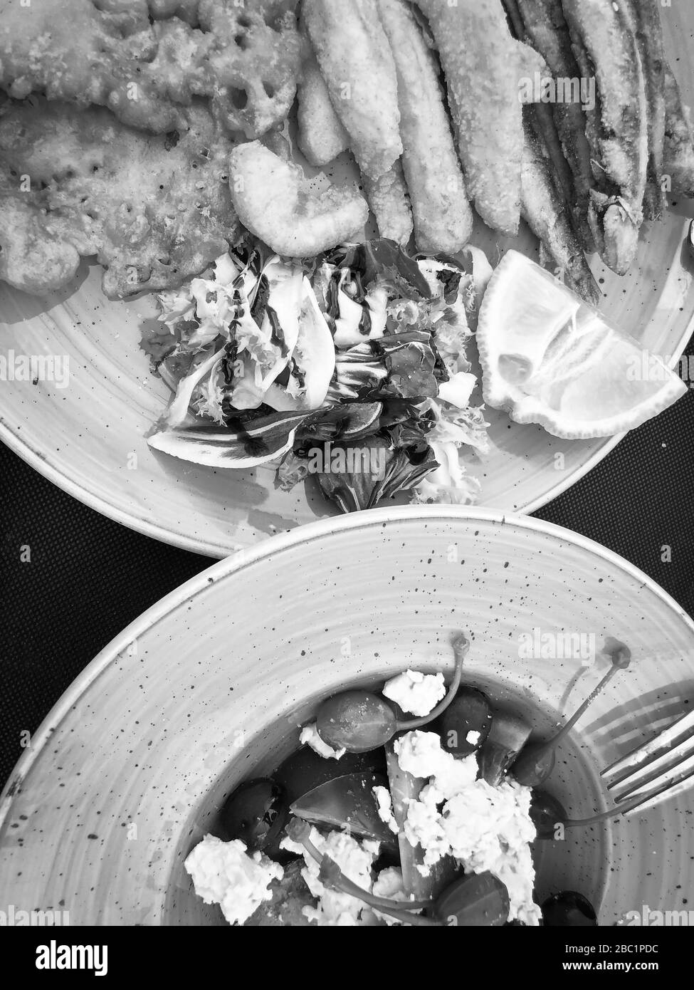 mischia i pesci fritti e il piatto di pesce con lattuga fresca e succo di limone Foto Stock
