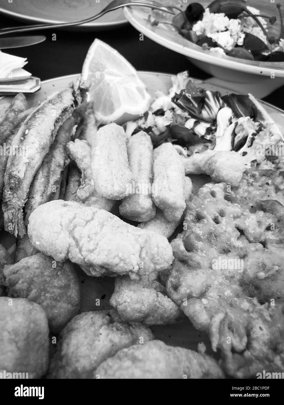 mischia i pesci fritti e il piatto di pesce con lattuga fresca e succo di limone Foto Stock