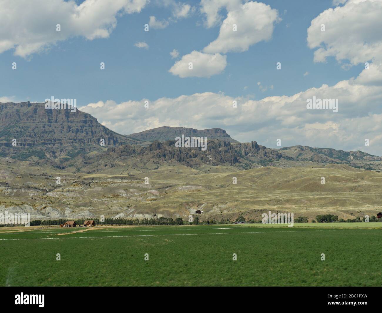 Lussureggianti pianure verdi con montagne in lontananza, parte del bellissimo paesaggio del Wyoming. Foto Stock