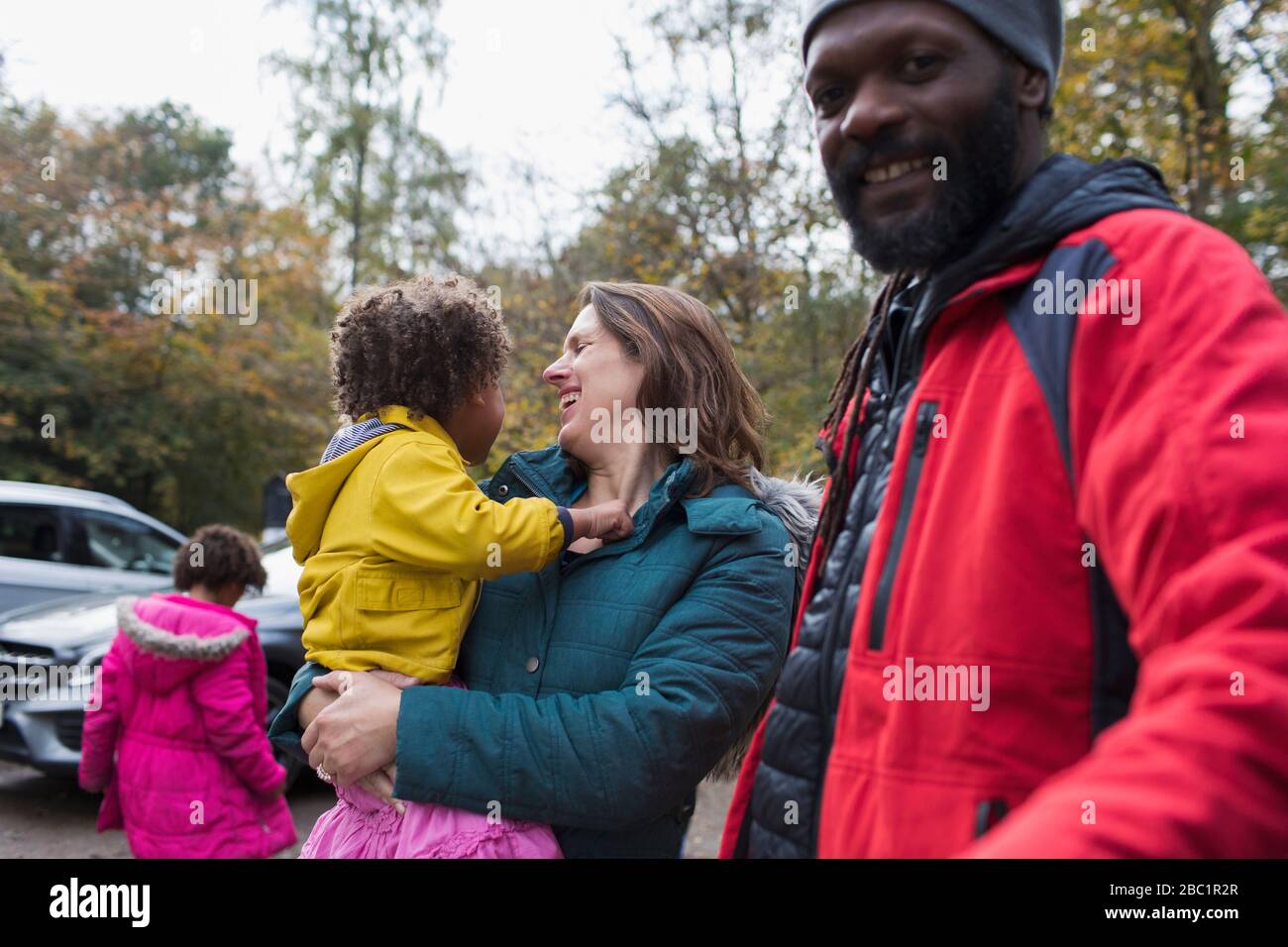 Felice famiglia multietnica nel parcheggio Foto Stock