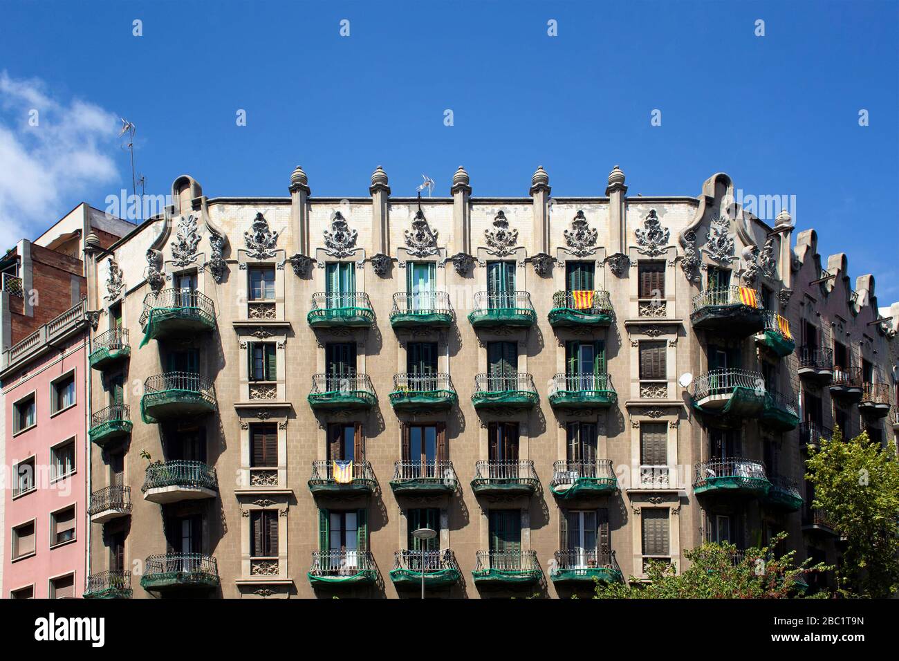 Vista degli edifici residenziali tradizionali, storici e tipici di Barcellona che mostrano lo stile architettonico spagnolo. Le bandiere catalane sono appese ai balconi. Foto Stock