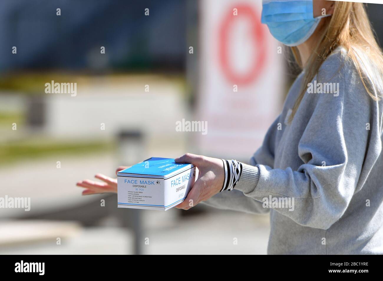 Monaco, Germania. 02nd Apr, 2020. Una donna con maschera facciale contiene una scatola dispenser con maschere monouso, maschera, maschera protettiva, maschera facciale. Troppe infezioni da corona: Muenchner Helios Klinik cede le operazioni quotidiane. A causa di un gran numero di infezioni da corona tra pazienti e dipendenti, il Muenchner Klinik cede temporaneamente le normali operazioni ospedaliere. Anche la sala d'emergenza è interessata. Questo è il modo in cui le catene di infezione dovrebbero essere rotte. Colpo esterno, edificio, il 2nd aprile 2020 | utilizzo in tutto il mondo credito: dpa/Alamy Live News Foto Stock
