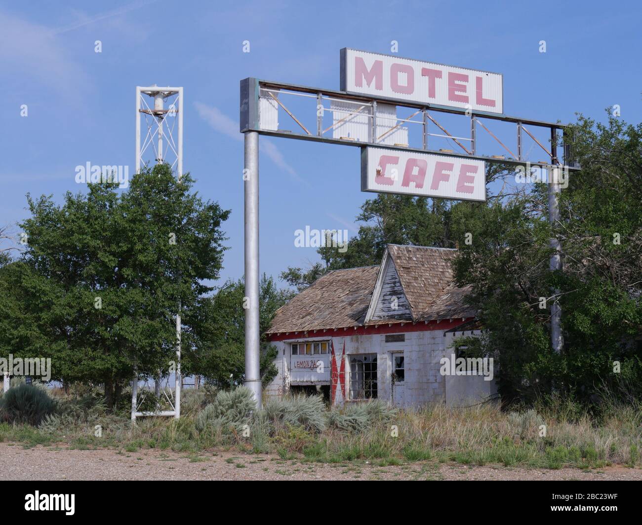 Glirio, New Mexico - Agosto 2018: Un motel e un caffè dilapidati coperti da alberi a Glirio, una delle città fantasma d'America. Foto Stock