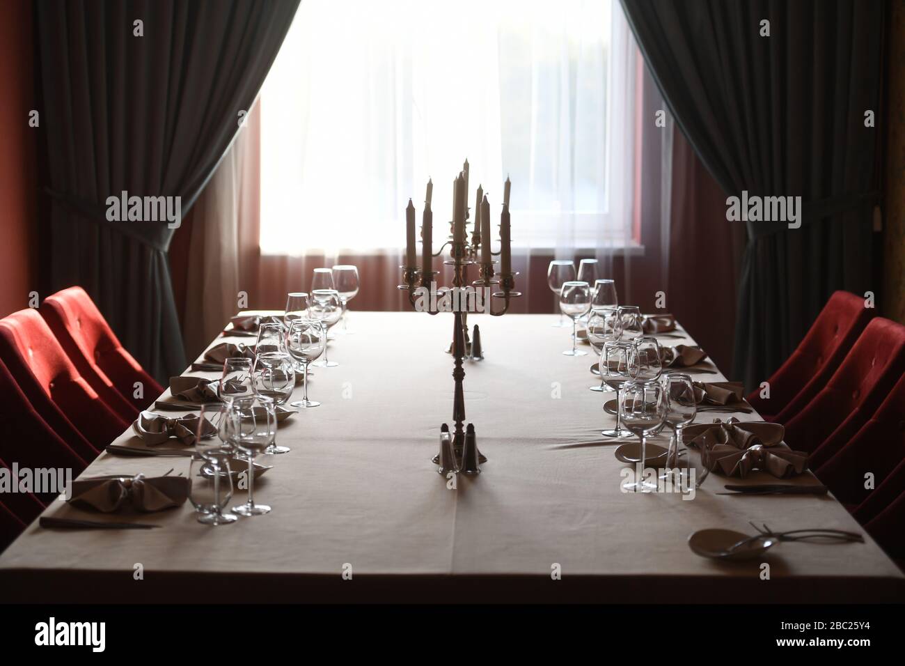 Elegante tavolo per cena con tende scure come sfondo Foto Stock