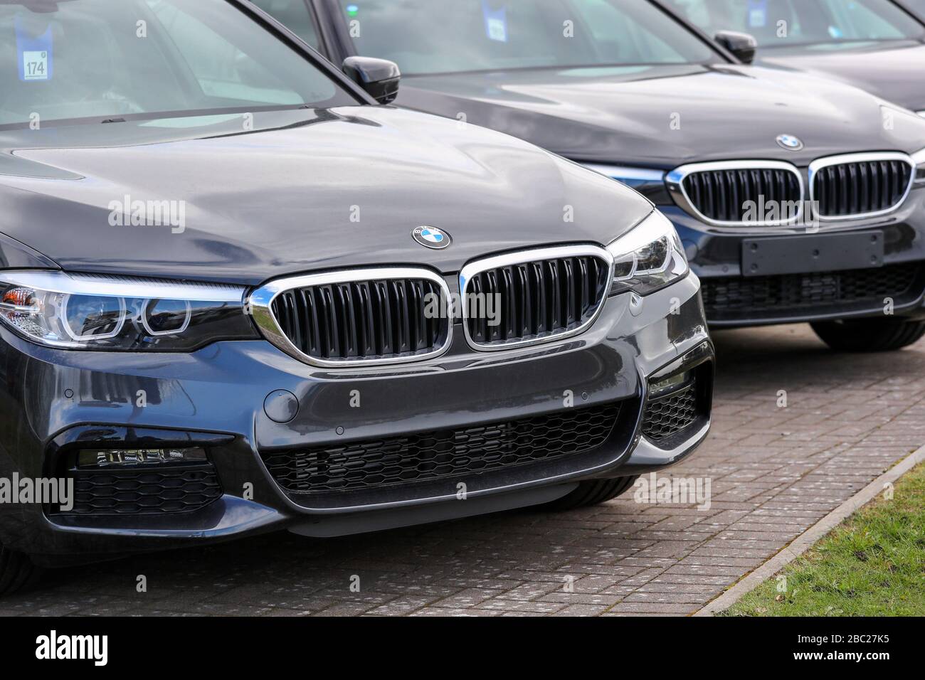Linea di nuovi berline BMW serie 3 in vendita, seduti in un piazzale garage, Foto Stock