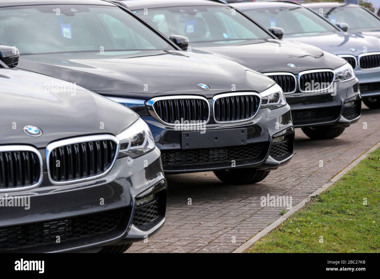 Linea di nuovi berline BMW serie 3 in vendita, seduti in un piazzale garage, Foto Stock
