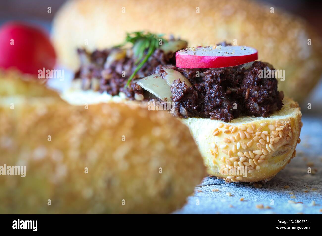 Primo piano sul rotolo di pane di mais con kaszanka caldo (salsiccia di sangue lucidato) stufato con cipolla Foto Stock