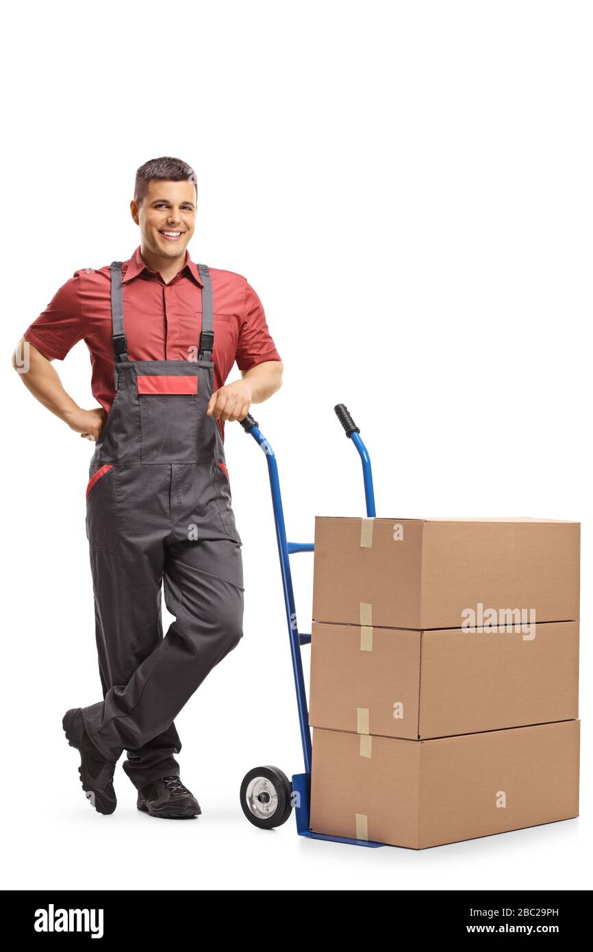 Lavoratore in una posizione eretta uniforme accanto a un camion a mano carico di scatole isolate su sfondo bianco Foto Stock