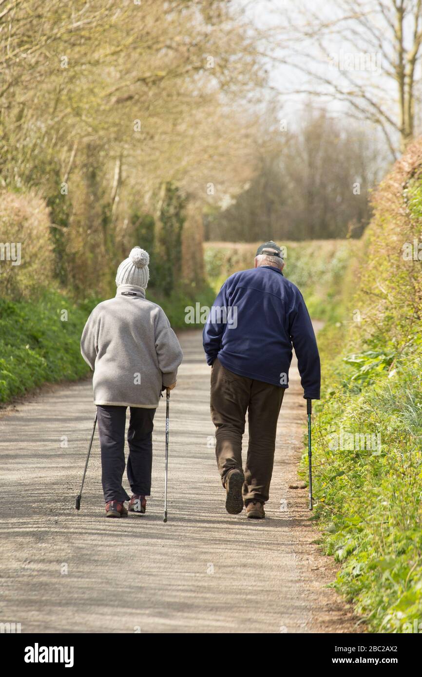 Una donna e un uomo anziani che camminano e prendono excercise durante lo scoppio di Coronavirus nel Regno Unito. Dorset Inghilterra GB Foto Stock