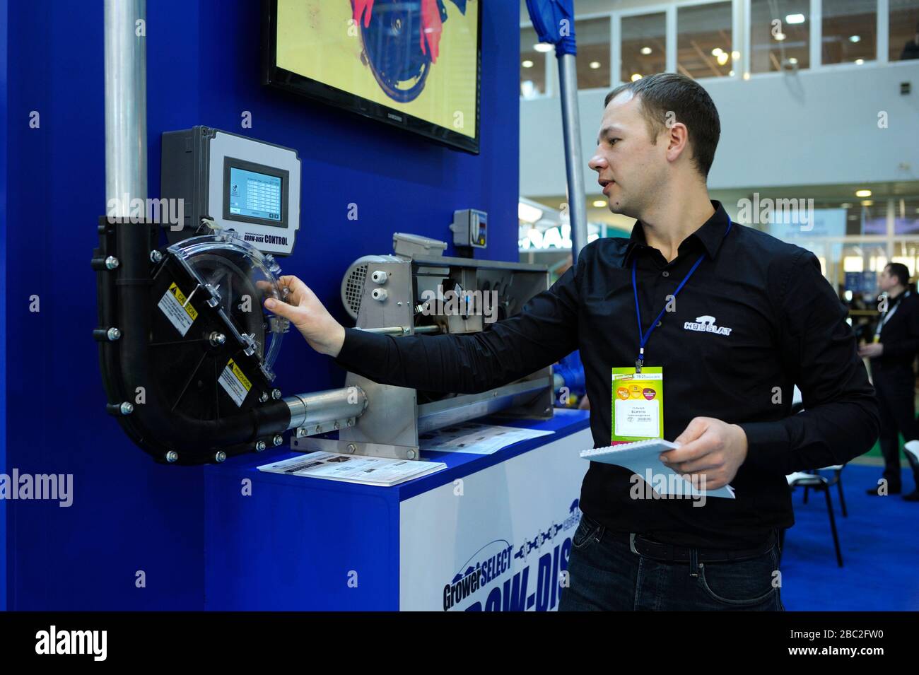 Responsabile vendite toccando il pannello di controllo di un sistema di trasporto di mangimi, usato in allevamento animale Foto Stock