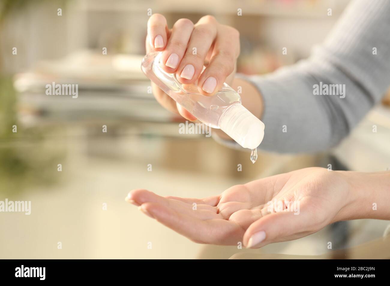 Primo piano di donna disinfezione della mano con gel disinfettante strofinare per prevenire il contagio seduto su una scrivania a casa Foto Stock Primo piano di donna disinfezione della mano con gel disinfettante strofinare per prevenire il contagio seduto su una scrivania a casa Foto Stock