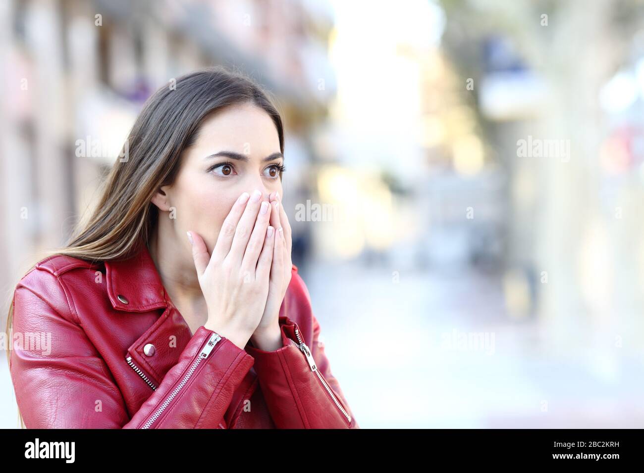Donna scioccata che guarda lontano in piedi in strada Foto Stock