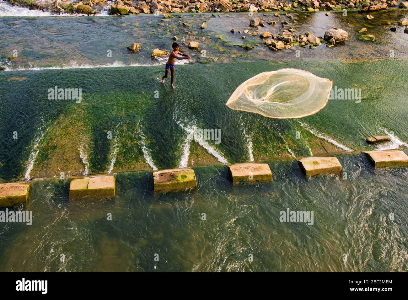 pescatore lancia un fishingnet per catturare pesce candid cattura Foto Stock